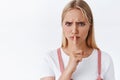 Close-up angry and furious serious-looking blond woman shushing demand silence, want you be quiet, press finger to lips