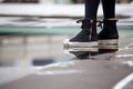 close up Ankle Sneakers of woman standing on water puddle on street in city Royalty Free Stock Photo