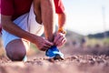 Close up annd portrait of man taking a break after running or jogging to fix his shoe to no fall Royalty Free Stock Photo