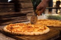 Close up of anonimous pizza chef slicing appetising pizza