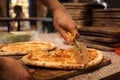 Close up of anonimous pizza chef slicing appetising pizza