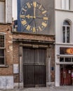 Close-up of an antique clock situated atop a brick building in Antwerp, Belgium