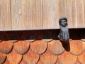 Close up of antique metal window shutter holder in the form of a woman's head, wooden shingles. Royalty Free Stock Photo