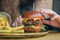 Close-up, appetizing burger and french fries in a cafe. Royalty Free Stock Photo