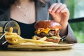 Close-up, appetizing burger and french fries in a cafe. Royalty Free Stock Photo