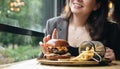 Close-up, appetizing burger and french fries in a cafe. Royalty Free Stock Photo