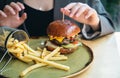 Close-up, appetizing burger and french fries in a cafe. Royalty Free Stock Photo