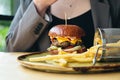 Close-up, appetizing burger and french fries in a cafe. Royalty Free Stock Photo