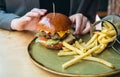 Close-up, appetizing burger and french fries in a cafe. Royalty Free Stock Photo