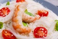 Rice noodles with cherry tomatoes, royal shrimp and fresh greens. Indoors. Close-up. Royalty Free Stock Photo