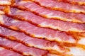 Close-up of appetizing slices of smoked bacon. Isolated on white background. Royalty Free Stock Photo