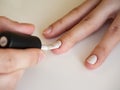 Close-up of applying white nail polish with a brush. Manicure at home. Poor-quality manicure Royalty Free Stock Photo