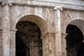 Close-up of the arches of the Colosseum with in the background the internal part of the walls soiled by the accumulation of dust