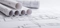 Close-up of architectural blueprint plans rolled up on a white surface for design