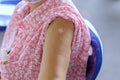 Arm of Thai Asian old woman with a plaster attached on upper arm after vaccination against COVID-19