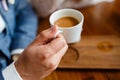 Close up of arms of successful business having a business meeting with his client in cafe. The man in suit is drinking coffee. Mor Royalty Free Stock Photo