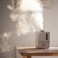 Close up of aroma oil diffuser on the table at home, steam from the air humidifier Royalty Free Stock Photo