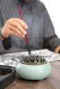 Close up of aromatherapy stove and calligraphers practicing calligraphy