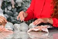 arrangement of Christmas baubles and other ornaments on a table with female hands. Christmas holiday and