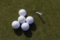 Close-up of an array of white golf balls on green grass