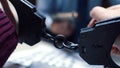 Close up of arrested criminal hands in handcuffs with detective interrogating on background Royalty Free Stock Photo