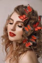 Close up art portrait of agirl with butterflies in her hair, european female with red lips and closed eyes Royalty Free Stock Photo