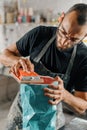 Close-up: artisan sculptor artist man works with sandpaper