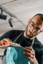 Close-up: artisan sculptor artist man works with sandpaper