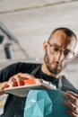 Close-up: artisan sculptor artist man works with sandpaper