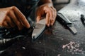 Close-up: artisan sculptor artist sharpening a blade on a sharpener in a workshop