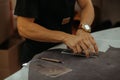 Close up of an artisan working with leather in his laboratory using tools. Handmade concept.