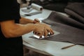 Close up of an artisan working with leather in his laboratory using tools. Handmade concept. Man holding crafting tool