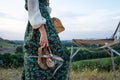 Close-up of an artist in a beautiful vintage dress with velvet shoes in her hand next to an easel in the open air Royalty Free Stock Photo