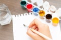 Close up of artist child`s hand draws gouache. Hand with brush painting. Selective focus Royalty Free Stock Photo