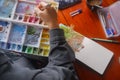 Close-up artist hand painting watercolours