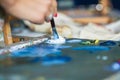 Artist mixes oil paints on pallet Royalty Free Stock Photo