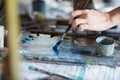 Artist mixes oil paints on pallet Royalty Free Stock Photo