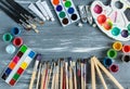 Close up of artist paint brushes, palette and watercolors on grunge gray wooden background. Set of multicolored paints Royalty Free Stock Photo