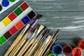 Close up of artist paint brushes, palette and watercolors on grunge gray wooden background. Royalty Free Stock Photo