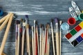 Close up of artist paint brushes, palette and watercolors on grunge gray wooden background. Set of multicolored paints Royalty Free Stock Photo