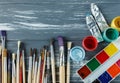 Close up of artist paint brushes, palette and watercolors on grunge gray wooden background. Set of multicolored paints Royalty Free Stock Photo