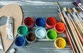 Close up of artist paint brushes, palette and watercolors on grunge gray wooden background. Set of multicolored paints Royalty Free Stock Photo