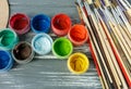 Close up of artist paint brushes, palette and watercolors on grunge gray wooden background. Set of multicolored paints Royalty Free Stock Photo