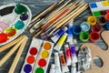 Close up of artist paint brushes, palette and watercolors on grunge gray wooden background. Set of multicolored paints Royalty Free Stock Photo