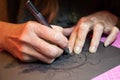 Close up of artists hands while making a custom designed paper cutting art work using a scalpel. Papercraft by hand