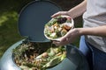 Close Up Of Woman Emptying Food Waste Into Garden Composter At Home Royalty Free Stock Photo