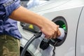 Asia men hands who are fueling a new vehicle electrification via rechargeable electricity machine