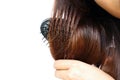 Close up Asia woman wear white shirt make hair color treatments hard combing her hairs on white background.