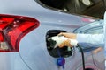 Close-up asia women hands who are fueling a new vehicle electrification