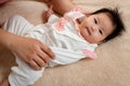 Close-up of Asian baby newborn girl face, lying on a soft brown bed, Single father cherishes the little boy`s hand, and sleeps Royalty Free Stock Photo